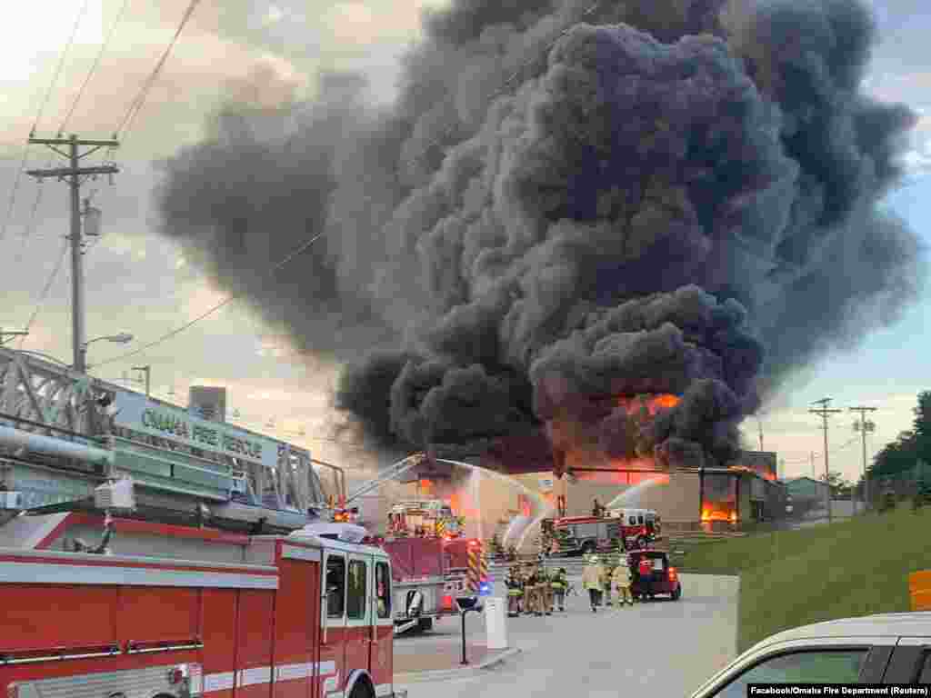 Firefighters extinguish a fire as smoke billows at a chemical plant in Omaha, Nebraska, May 30, 2022 in this picture obtained from social media. 