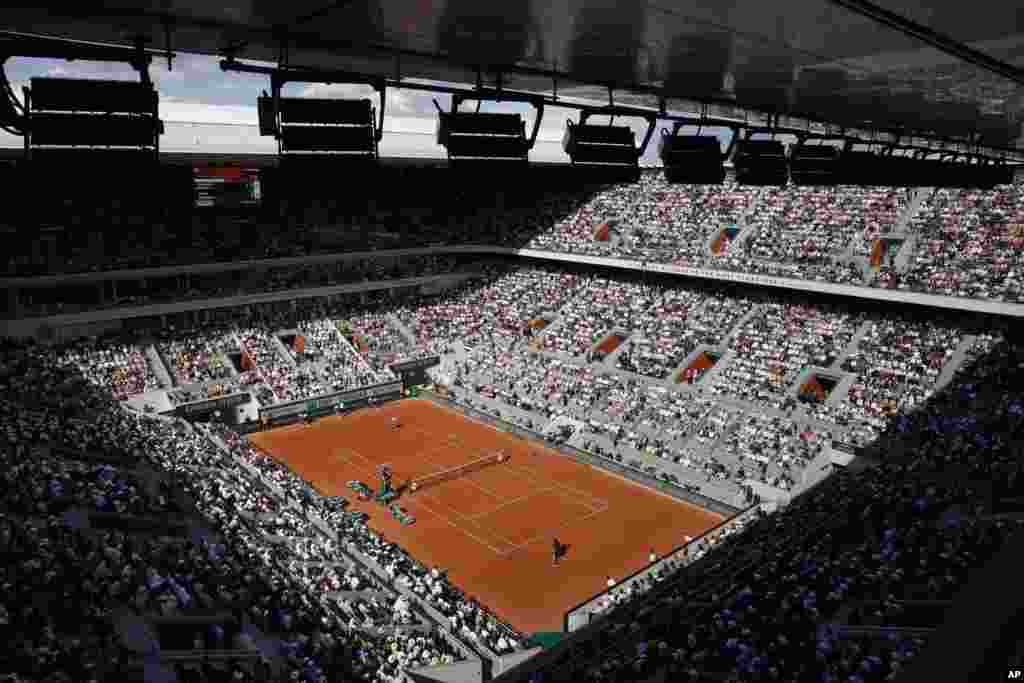 The public watch Spain&#39;s Carlos Alcaraz playing Germany&#39;s Alexander Zverev, front, during their quarterfinal match of the French Open tennis tournament at the Roland Garros stadium in Paris.