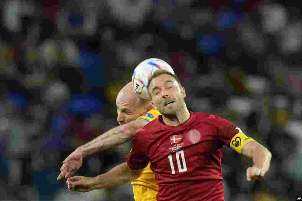 Denmark&#39;s Christian Eriksen, foreground, and Australia&#39;s Aaron Mooy jump for the ball during the World Cup group D soccer match between Australia and Denmark, at the Al Janoub Stadium in Al Wakrah, Qatar.