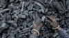 FILE - A woman works at a coal depot in Ahmedabad, India, May 2, 2022.