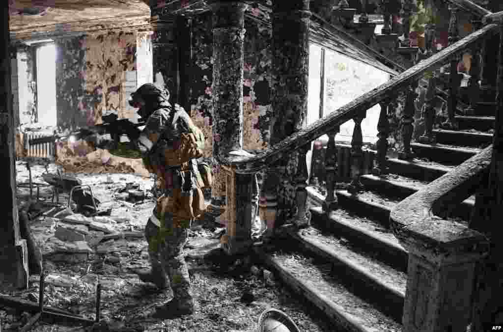 A Russian soldier patrols the Mariupol drama theater that was bombed last month as Russian troops intensify a campaign to take the strategic port city of Mariupol.&nbsp;This picture was taken during a trip organized by the Russian military.