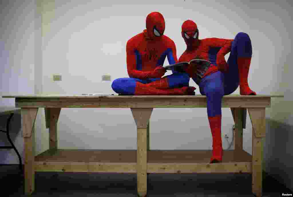 Kris Hamilton dan Peter Norbot yang mengenakan kostum Spider-Man, membaca majalah sambil menunggu giliran untuk melakukan audisi bagi promosi film baru "The Amazing Spider-Man 2" di kota Chicago, AS. 