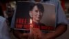 Seorang demonstran memegang plakat dan lilin selama protes menentang kudeta militer di Yangon, Myanmar, 16 Februari 2021. (Foto: Reuters)