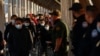 FILE - Migrants expelled from the U.S. and sent back to Mexico under Title 42 walk toward Mexico at the Paso del Norte International border bridge on April 1, 2022. 