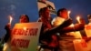 People hold candles and placards during a vigil for the soldiers who were killed after gunmen attacked an Indian army base in Kashmir's Uri, Mumbai, India, Sept. 19, 2016.