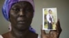 FILE-In this Monday, May 19, 2014 file photo, Martha Mark, the mother of kidnapped school girl Monica Mark cries as she displays her photo, in the family house, in Chibok, Nigeria.