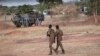 Des officiers de l'armée burkinabè patrouillent près d'un véhicule blindé français stationné à Kaya, capitale de la région du centre-nord du Burkina Faso, après que des personnes ont protesté contre le passage d'un grand convoi logistique de l'armée française.
