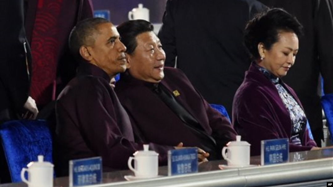 U.S. President Barack Obama, left, and Chinese President Xi Jinping, center, prepare to watch a firework show during the Asia-Pacific Economic Cooperation (APEC) summit in Beijing Monday, Nov. 10, 2014. At right is Xi's wife Peng Liyuan. (AP Photo/Wang 
