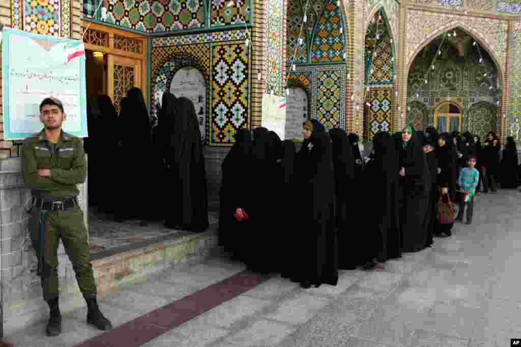 Women stand in line at a polling station during the presidential election in Qom, Iran, June 14, 2013.