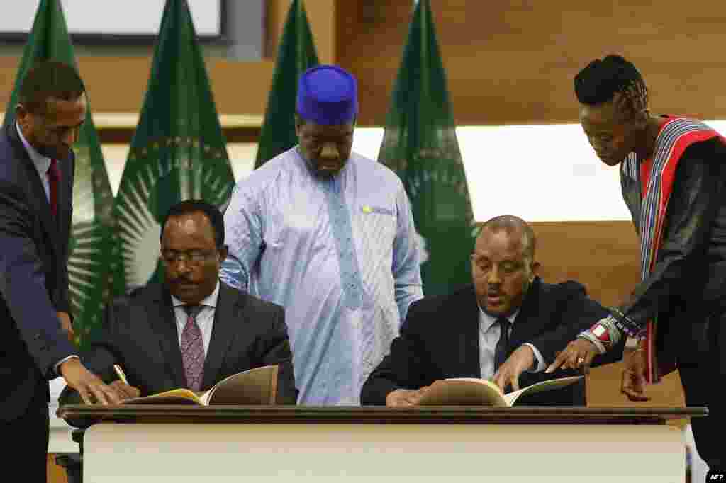 Redwan Hussien Rameto, 2nd left, representative of the Ethiopian government, and Getachew Reda, 2nd right, representative of the Tigray People&#39;s Liberation Front (TPLF), sign a peace agreement between the two parties during a press conference regarding the African Union-led negotiations to resolve conflict in Ethiopia at the Department of International Relations and Cooperation offices in Pretoria, South Africa.