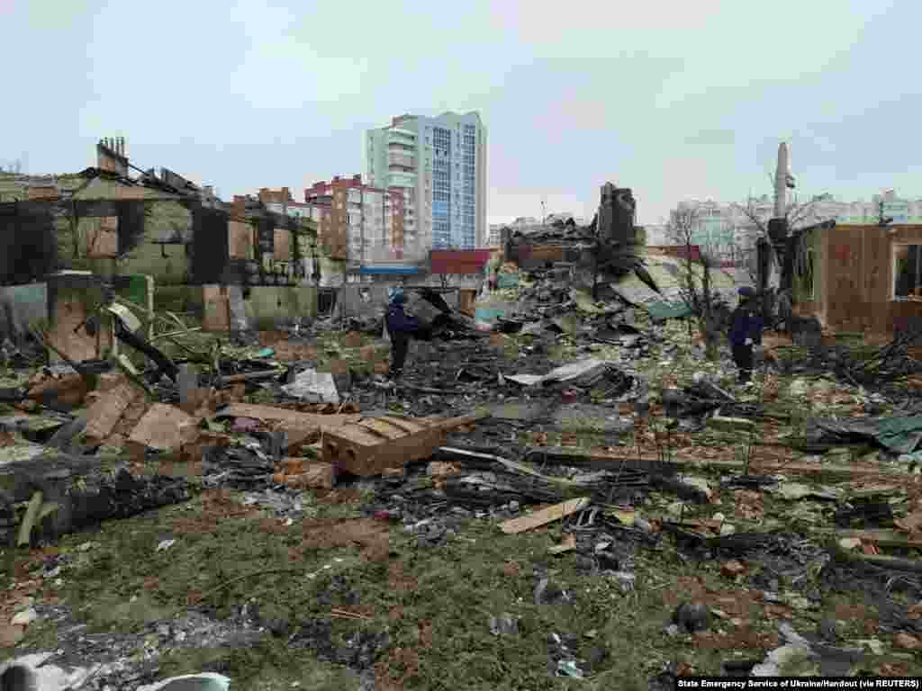 Members of Ukrainian emergency services stand amid rubble in Chernihiv as Russia&#39;s invasion of Ukraine continues, March 9, 2022.