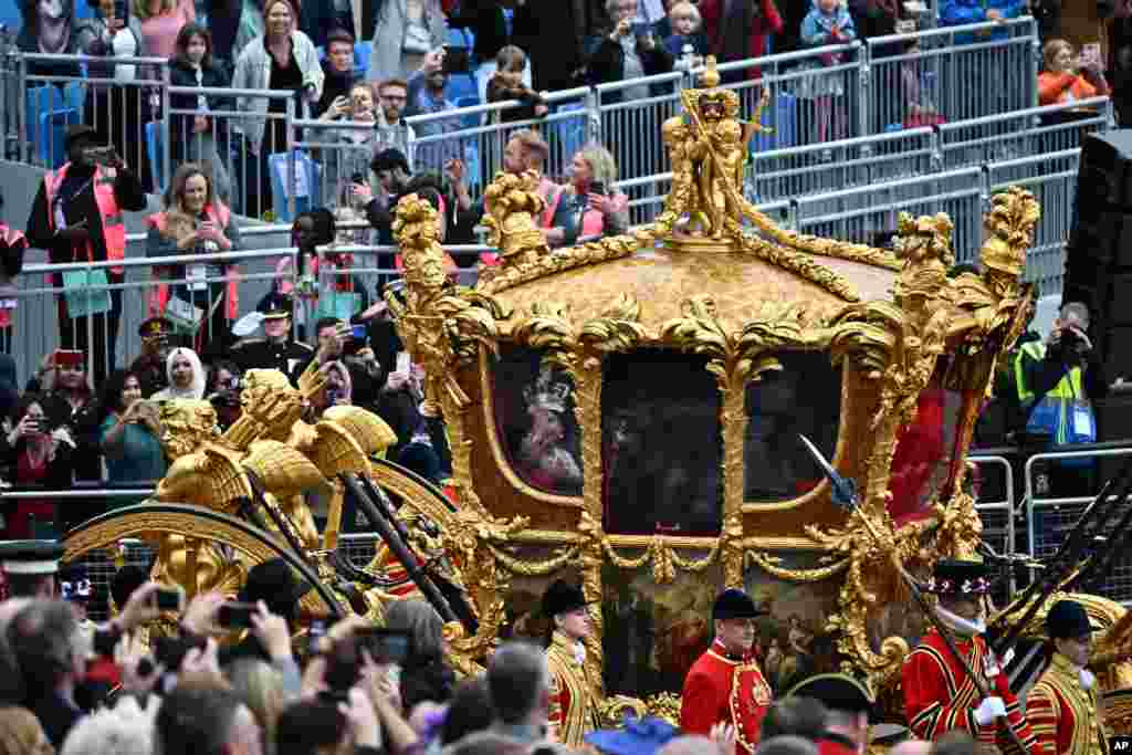 Attendees take pictures of the hologram of Britain&#39;s Queen Elizabeth II projected on the Gold State Coach during the Platinum Jubilee Pageant outside Buckingham Palace in London on the last of four days of celebrations to mark the Platinum Jubilee.