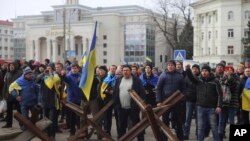 People shout toward Russian army soldiers during a rally against the Russian occupation in Svobody (Freedom) Square in Kherson, Ukraine, Monday, March 7, 2022