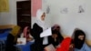 FILE - Kerishma Rasheedi, 16, reads during a class at a private school class in Kabul, Afghanistan, Aug. 3, 2022. 