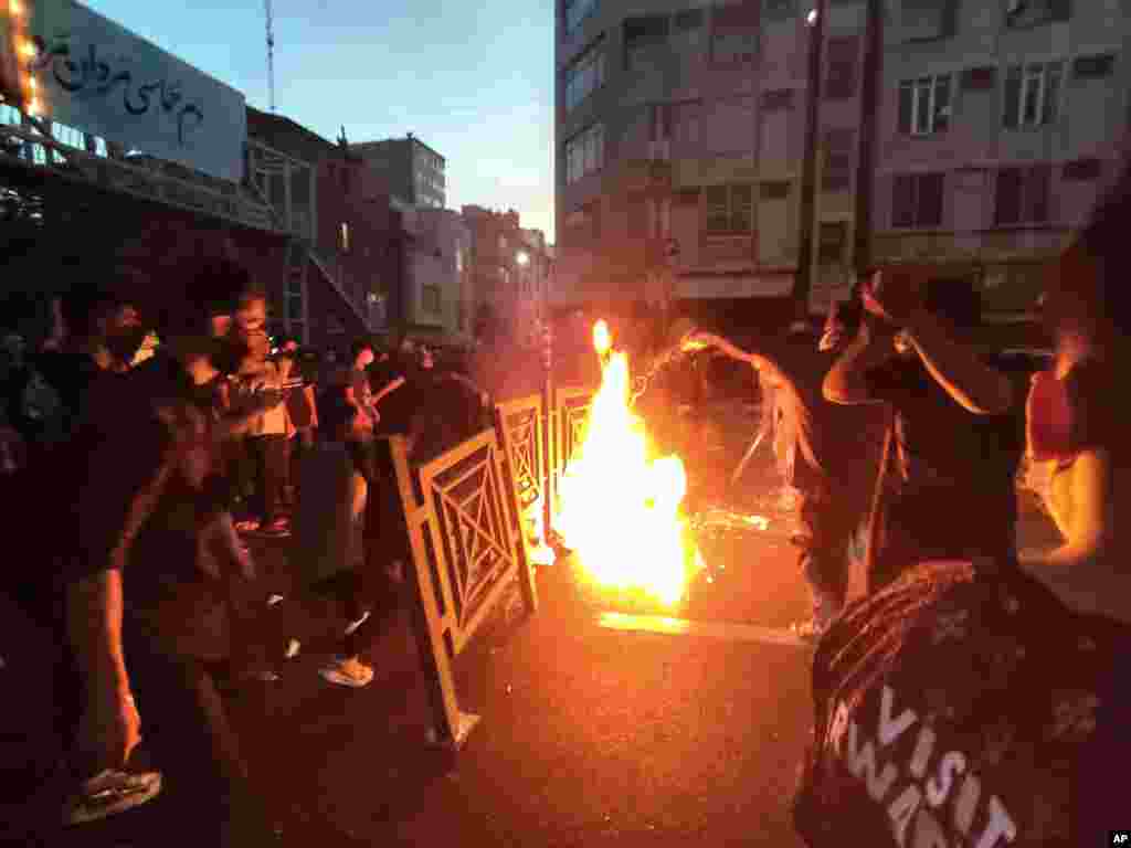In this Sept. 21, 2022 photo, taken by an individual not employed by the Associated Press and obtained by AP outside Iran, protesters set a fire and block a street during a protest over the death of a woman who was detained over &quot;unsuitable attire,&quot; in downtown Tehran.
