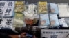 FILE - Members of the media take photos of evidence, including children's books trying to explain the city's democracy movement, at a police press conference in Hong Kong, July 22, 2021, after five people were charged with sedition for publishing the titles. 