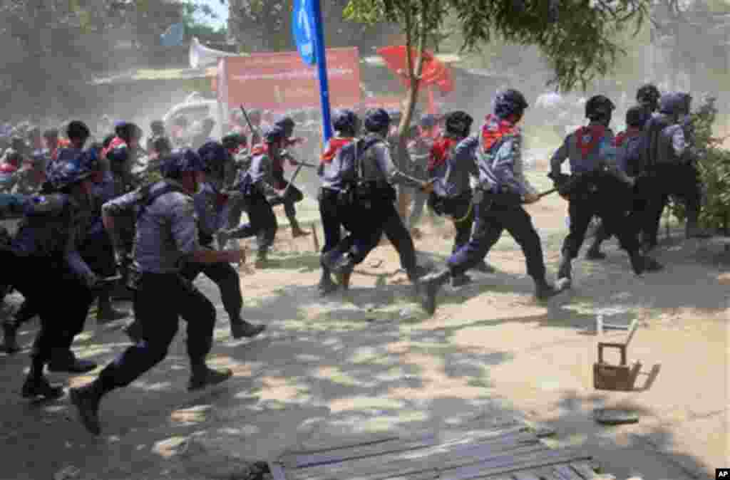 Polisi Myanmar bersenjatakan tongkat mengejar pada demonstran di Letpadan, Myanmar (10/3). (AP/Khin Maung Win)
