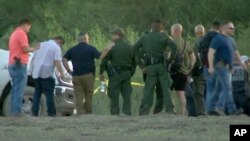 In this frame grab taken from video provided by KRGV, authorities gather near where a helicopter flying over the U.S.-Mexico border in Texas crashed, killing two National Guard soldiers and a U.S. Border Patrol agent on March 8, 2024. (KRGV via AP)