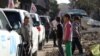 Vehicles of the International Committee of the Red Cross (ICRC), the Syrian Arab Red Crescent and the United Nations wait on a street after an aid convoy entered the rebel-held Syrian town of Daraya, southwest of the capital Damascus, on June 1, 2016.