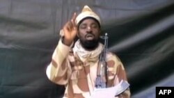 A grab made on July 13, 2013 from a video obtained by AFP shows the leader of the Islamist extremist group Boko Haram Abubakar Shekau, dressed in camouflage and holding an Kalashnikov AK-47. (AFP photo/Boko Haram) 