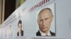 A board with the profiles of various presidential candidates, amongst them Russia's current Prime Minister Vladimir Putin, is on display during the preparations for the upcoming presidential elections at a polling station in the southern Russian city of S