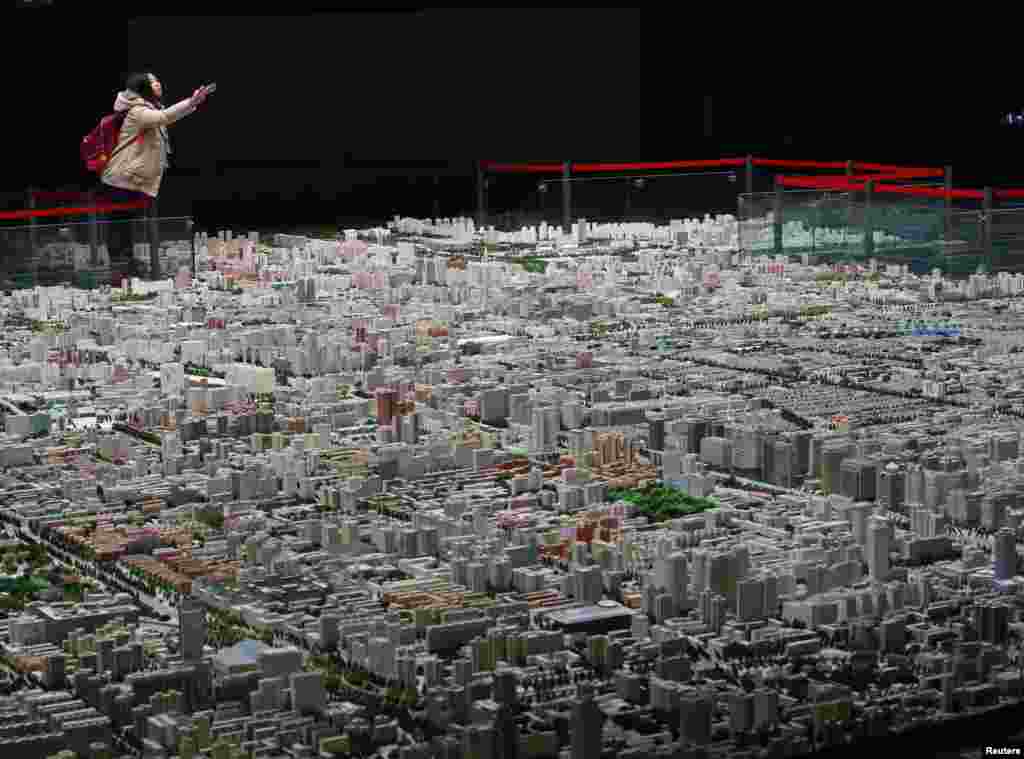 Seorang pengunjung mengambil foto sebuah model kota Beijing yang dipamerkan di sebuah museum di Beijing, China.