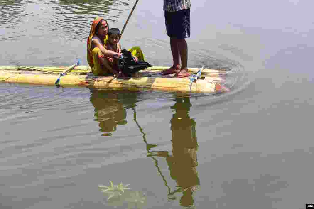 Villagers travel on a makeshift raft in flood waters of Hatibhangi village in the Morigaon district, in India&#39;s Assam state.