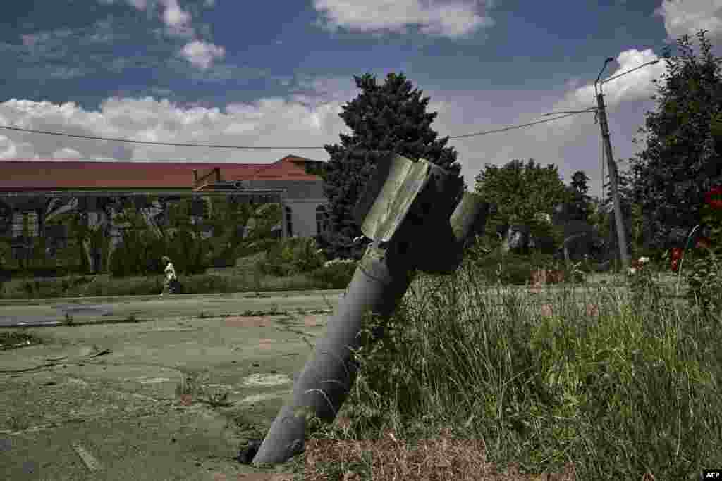 The tail of a rocket is nailed into pavement in the city of Lysychansk at the eastern Ukrainian region of Donbas, as the Russian-Ukraine war enters its 114th day. 