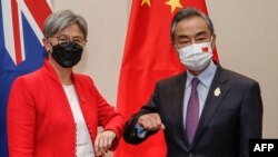 2022年7月8日，在印尼度假胜地巴厘岛努沙杜瓦举行的二十国集团外长会议期间，澳大利亚外交部长黄英贤(左)与中国外交部长王毅碰肘互致问候。