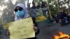 Seorang siswa memegang poster 'Ibu Pertiwi Sedang Stand Up Comedy' pada hari kedua aksi unjuk rasa menentang UU Omnibus Penciptaan Lapangan Kerja, di Tangerang, 7 Oktober 2020. ( FAJRIN RAHARJO / AFP)