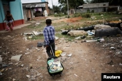 A boy pulls his school bag at a favela, or a slum, in Rio de Janeiro, Brazil, June 24, 2016.