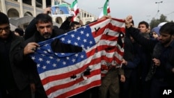 Demonstranti cijepaju američku zastavu na protestu zbog vazdušnog udara u Iraku u kome je ubijen general Revolucionarne garde Qassem Soleimani u Teheranu, 3. januara 2020.