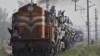 FILE - Passengers travel on an overcrowded train at Loni town in the northern Indian state of Uttar Pradesh.