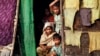 FILE - A Myanmar Muslim family, who identify themselves as long-persecuted “Rohingya” Muslims, look out from their tents at Da Paing camp for Muslim refugees in north of Sittwe, Rakhine State, western Myanmar.