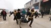 Emergency services carry a body of a person killed in a government airstrike in the city of Idlib, Syria, Feb. 11, 2020. 
