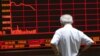 An investor watches an electronic board showing stock information at a brokerage office in Beijing, China, July 7, 2015.