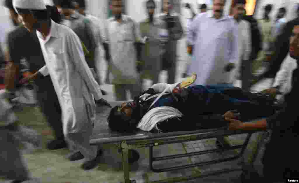 A man injured in a suicide bomb attack is wheeled on a stretcher as he arrives at the Lady Reading Hospital for treatment in Peshawar, Paksitan, June 21, 2013.
