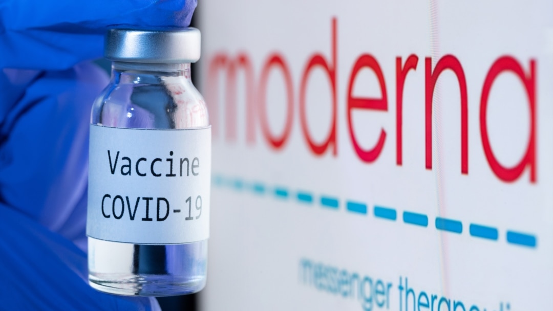 This picture taken on November 18, 2020 shows a bottle reading "Vaccine Covid-19" next to the Moderna biotech company logo. (Photo by JOEL SAGET / AFP)