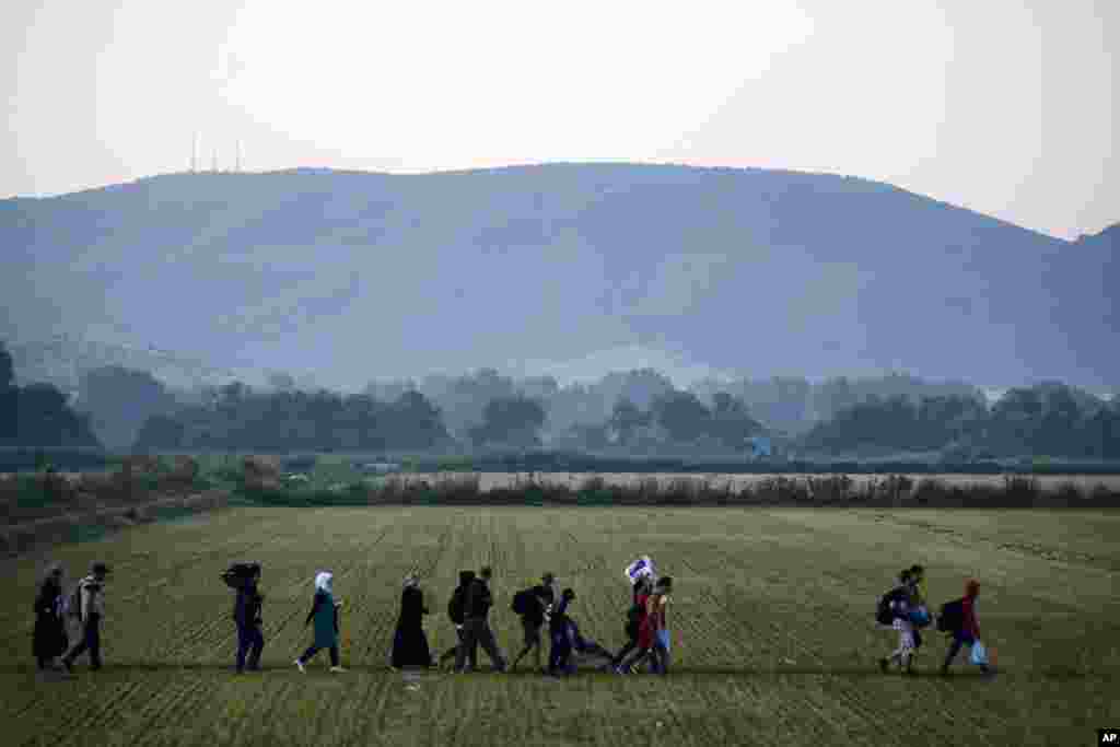 Migrants approach the border checkpoint in the northern Greek town of Idomeni, and cross into southern Macedonia, Sept. 3, 2015. Macedonia has borne the brunt of a massive refugee and migration flow of people heading into the European Union, with more than 200,000 people arriving so far this year.