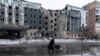 A woman walks past a building damaged by a Russian military strike in the town of Pokrovsk