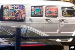 FILE - This Nov. 1, 2017, photo shows a van with windows covered with an assortment of stickers in Well, Florida. Federal authorities took Cesar Sayoc into custody on Oct. 26, 2018, and confiscated his van, which appears to be the same one.