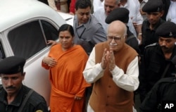 FILE - Indian opposition leader and President of Bharatiya Janta Party (BJP) L.K. Advani, center right, and senior BJP leader Uma Bharti, center left, arrive at a court in Rae Bareilly, in the northern Indian state of Uttar Pradesh.