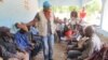 A UNICEF worker recruits participants for a community watch committee in Daro, a village in Guinea’s forest region. (Christophe Boulierac / UNICEF) 