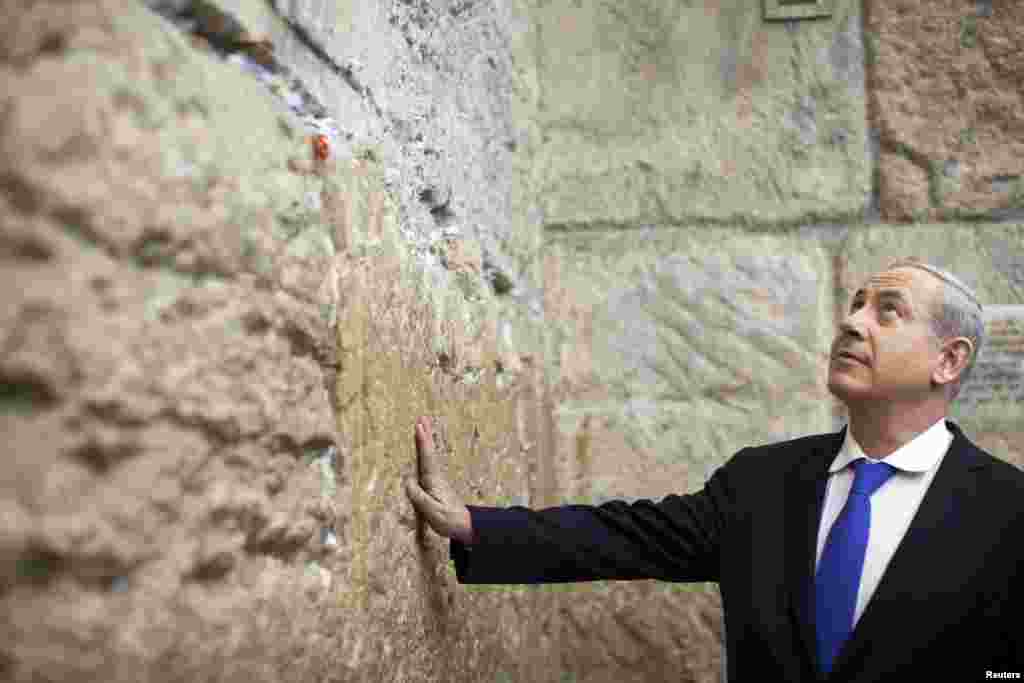 Israel's Prime Minister Benjamin Netanyahu touches the Western Wall in Jerusalem's Old City after casting his ballot in Israel's parliamentary election January 22, 2013.