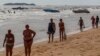 Tourists walk on a beach in Pattaya, June 6, 2014.