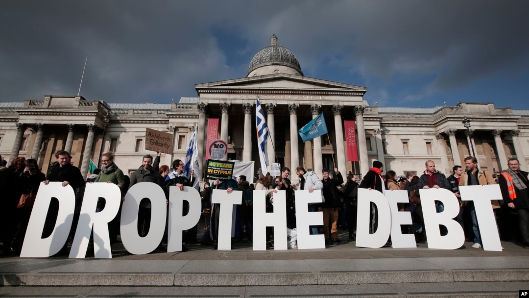 Backdropped by Britain's National Gallery in central London, protesters hold placards during a rally to show solidarity with Greece, Sunday, Feb. 15, 2015. 
