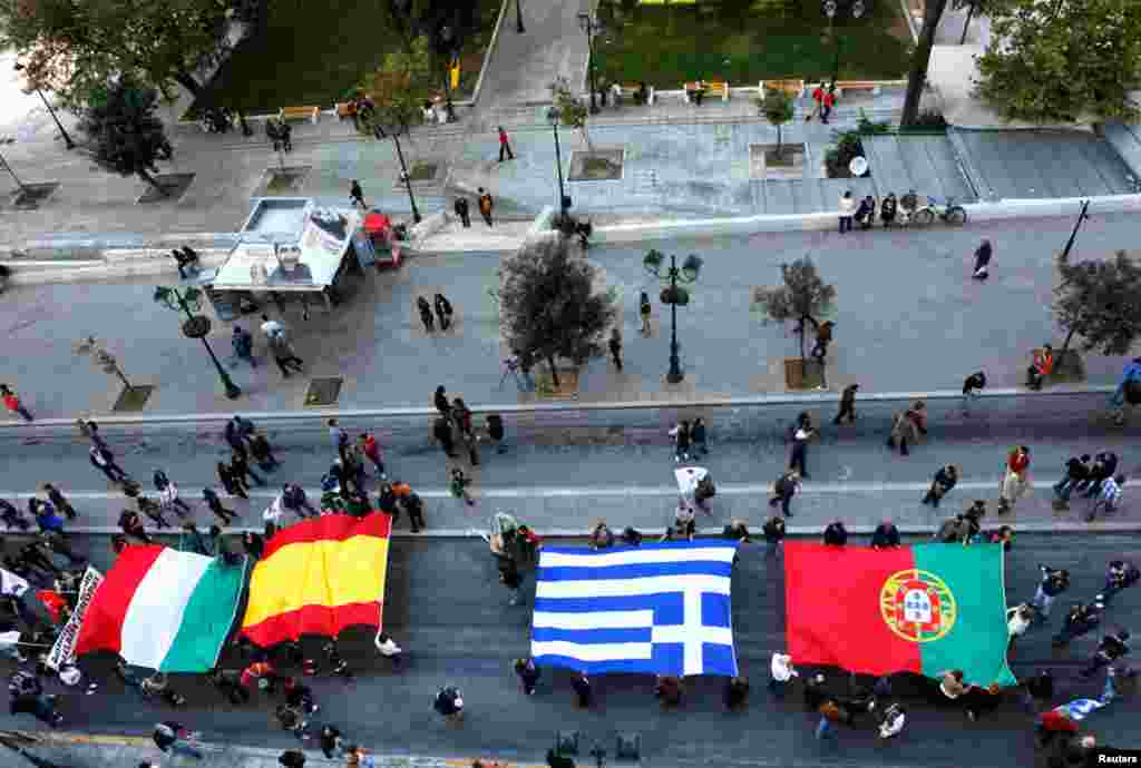 Protesters march through Syntagma square in Athens with flags of Italy, Spain, Greece and Portugal, November 14, 2012.