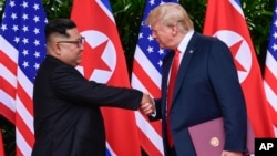 도널드 트럼프 미국 대통령과 김정은 북한 국무위원장이 지난해 6월 싱가포르에서 첫 정상회담을 마친 후 악수하고 있다.