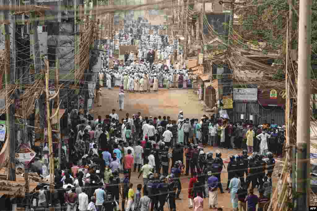 Activists of the Hifazat-e Islam group clash with police, in foreground, in Chittagong during a demonstration against Indian Prime minister Narendra Modi&#39;s visit to Bangladesh.