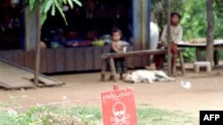 Trẻ em đang ngồi chơi gần một bãi mìn ngay phía ngoài nhà của các em trong tỉnh Battambang